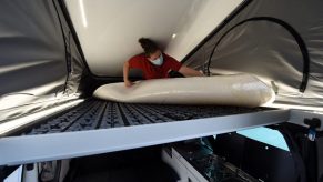 A worker installs the bed in the retractable tent on the roof of a Renault "Trafic" van converted into a motorhome, in the factory of the Pilote group, in Longuenee-en-Anjou, western France