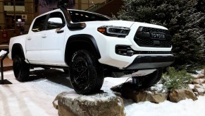 A white Toyota Tacoma pictured at an auto show.