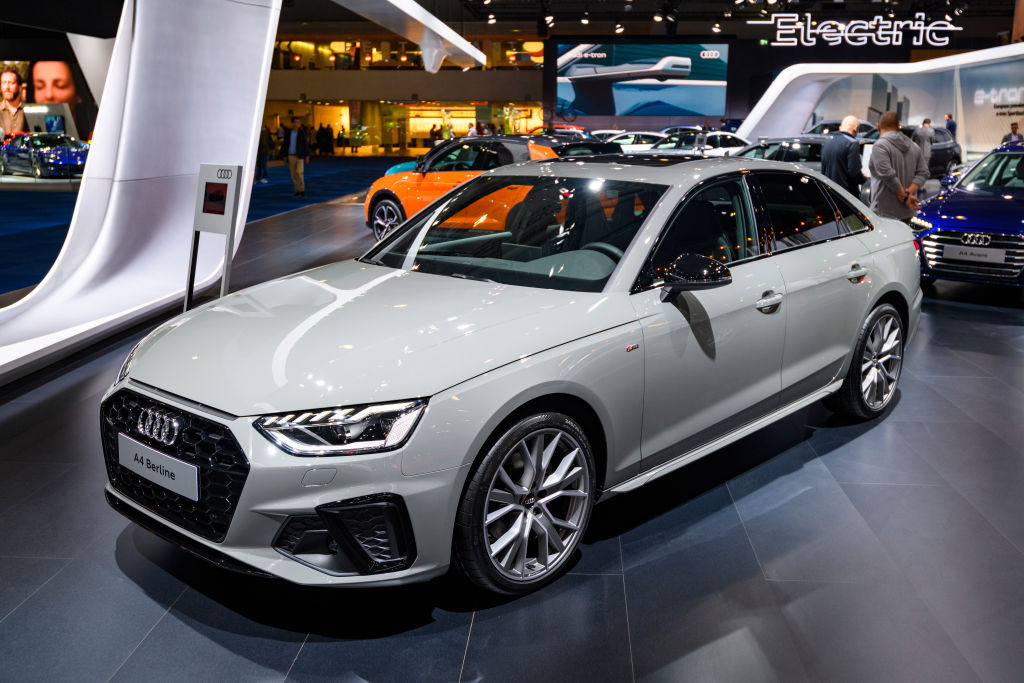 The 2021 Audi A4 in Nardo Grey at an auto show, with other models in the  background.