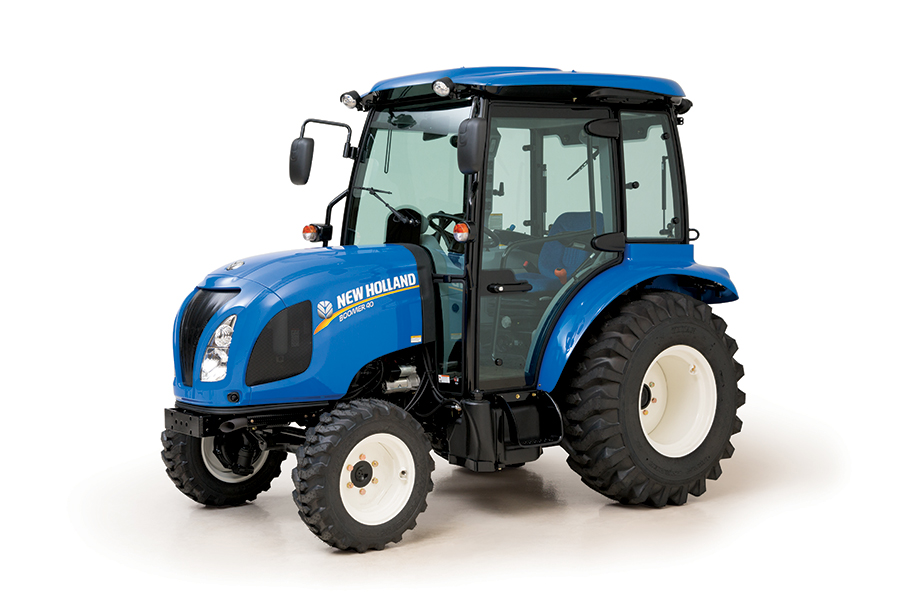 a blue new holland compact tractor with a cab in a press photo against a white backdrop. 