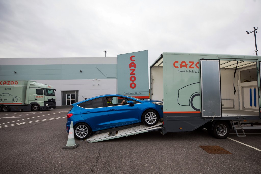 An employee drives a second-hand Ford Motor Co. Fiesta automobile onto a car transporter.