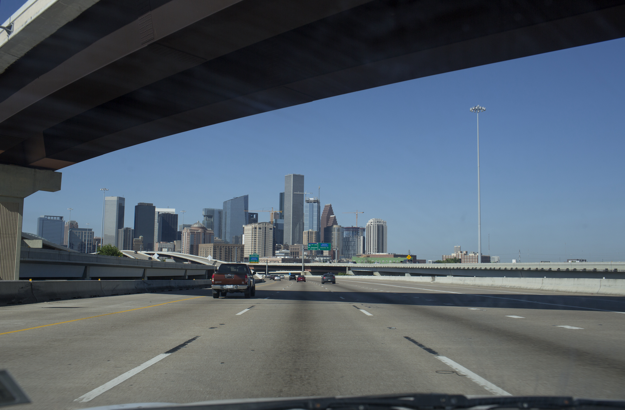 The Houston skyline appears above an intersection of freeways approaching from the east on April 11, 2021, in Houston, Texas on a post-vaccination road trip