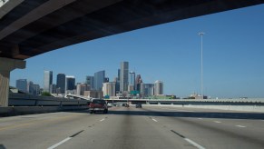 The Houston skyline appears above an intersection of freeways approaching from the east on April 11, 2021, in Houston, Texas on a post-vaccination road trip