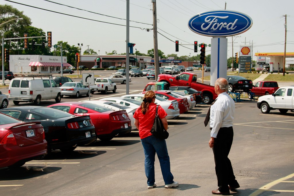 A salesman helps out a customer at a Ford dealership. 