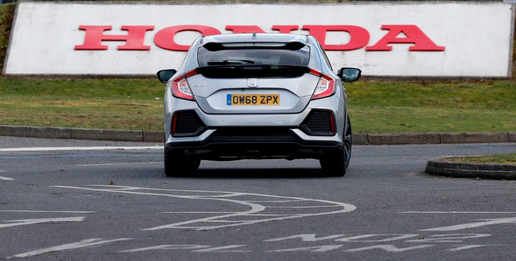 A silver honda civic rear end on the track