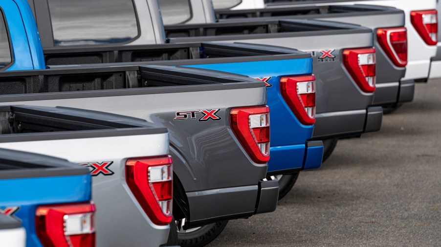 a row of 2021 Ford F-150 pickup trucks in a row on the sales lot
