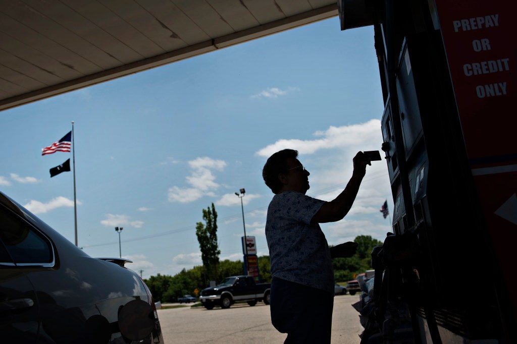 A customer prepares to scan her credit card while getting fuel at a Road Ranger gas station.