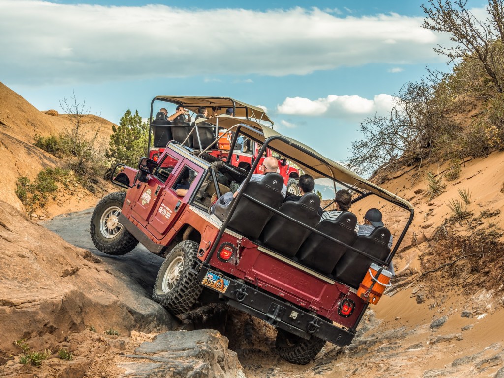 a red Hummer H1 traversing Hell's Revenge Moab