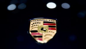 Closeup of a Porsche badge on a black car
