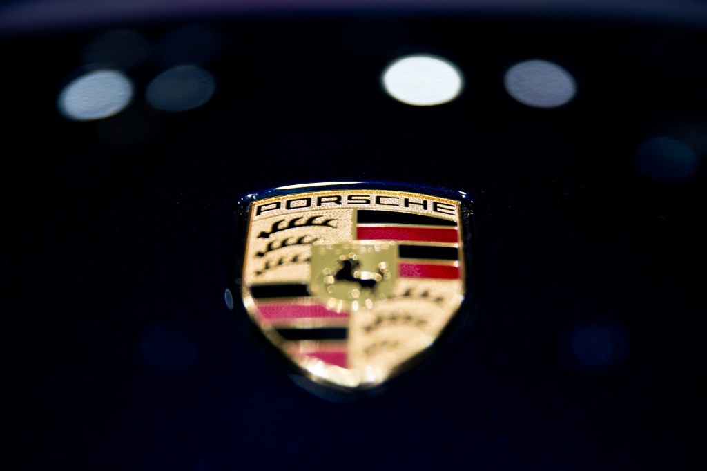 Closeup of a Porsche badge on a black car