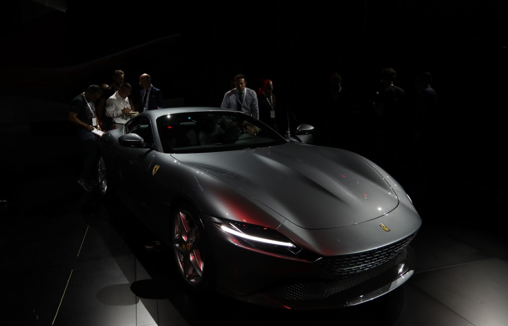 A grey Ferrari Roma, presumably sans CarPlay, shown on stage at it's reveal in Rome.
