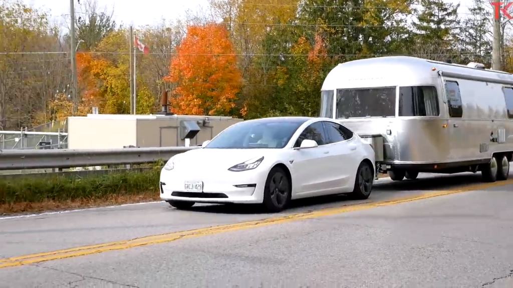 A shot of a Tesla Model 3 Towing an airstream trailer