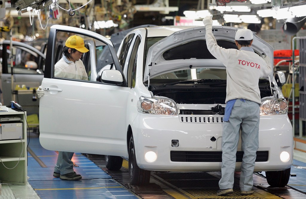 Toyota employees assemble a vehicle on the production line
