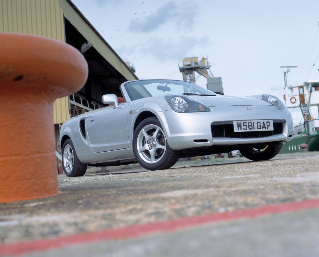 A silver toyota mr2 spyder with the convertible top down