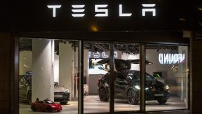 A black Tesla Model X on display in a showroom at night