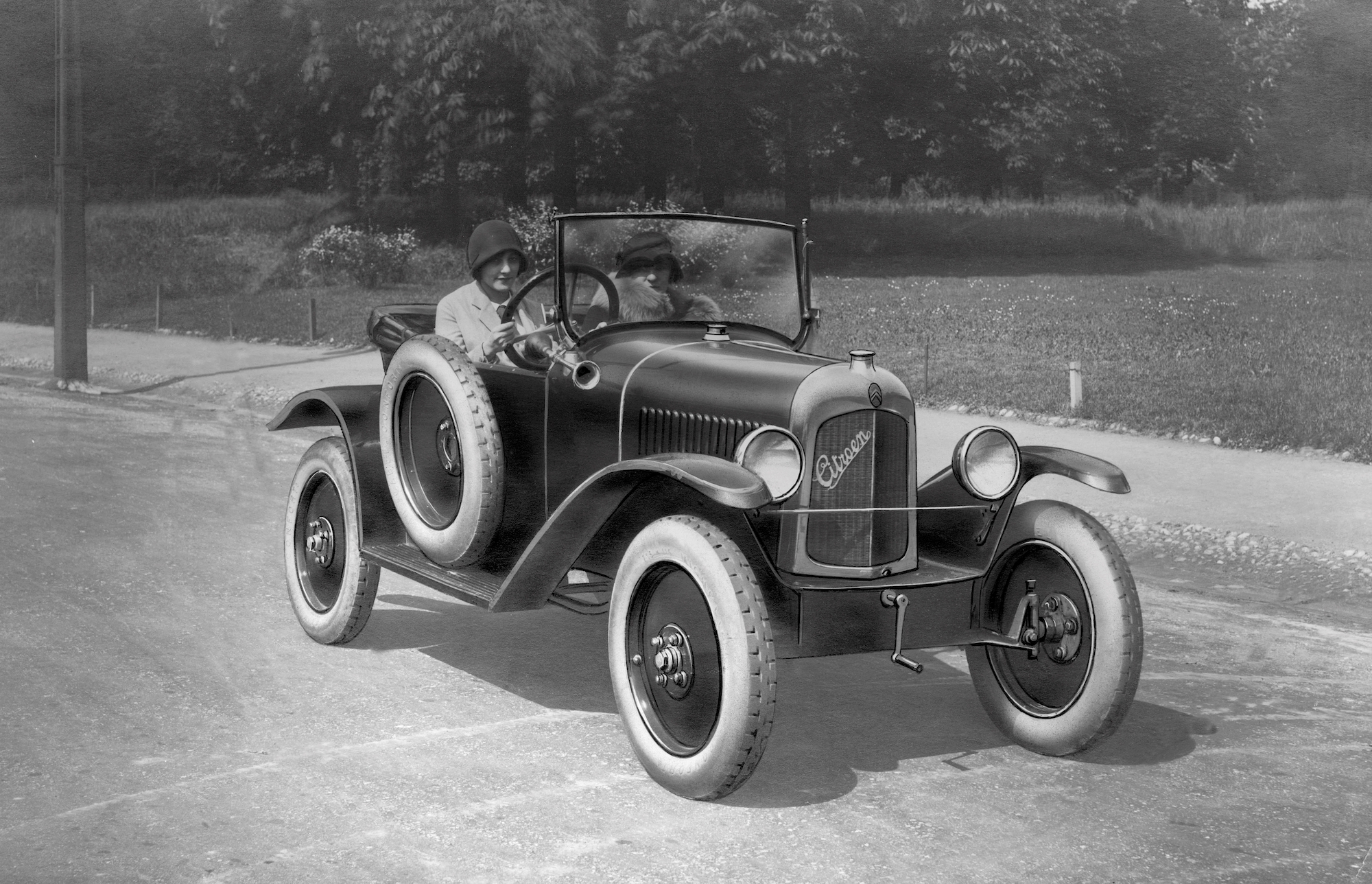 A black-and-white photo of two women driving in a Citroen car circa 1920-30