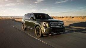 a Kia Telluride SUV driving at speed on a desert highway
