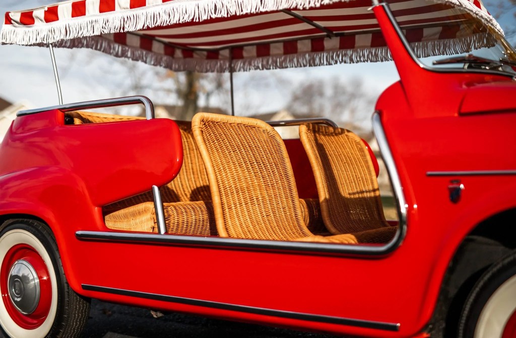 A side view of the wicker interior of a red 1958 Fiat Jolly 600
