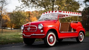 A red 1958 Fiat Jolly 600 parked on a driveway