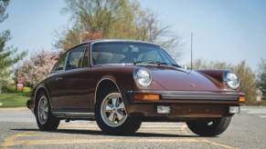 The front 3/4 view of a brown 1975 Porsche 911 S in a parking lot