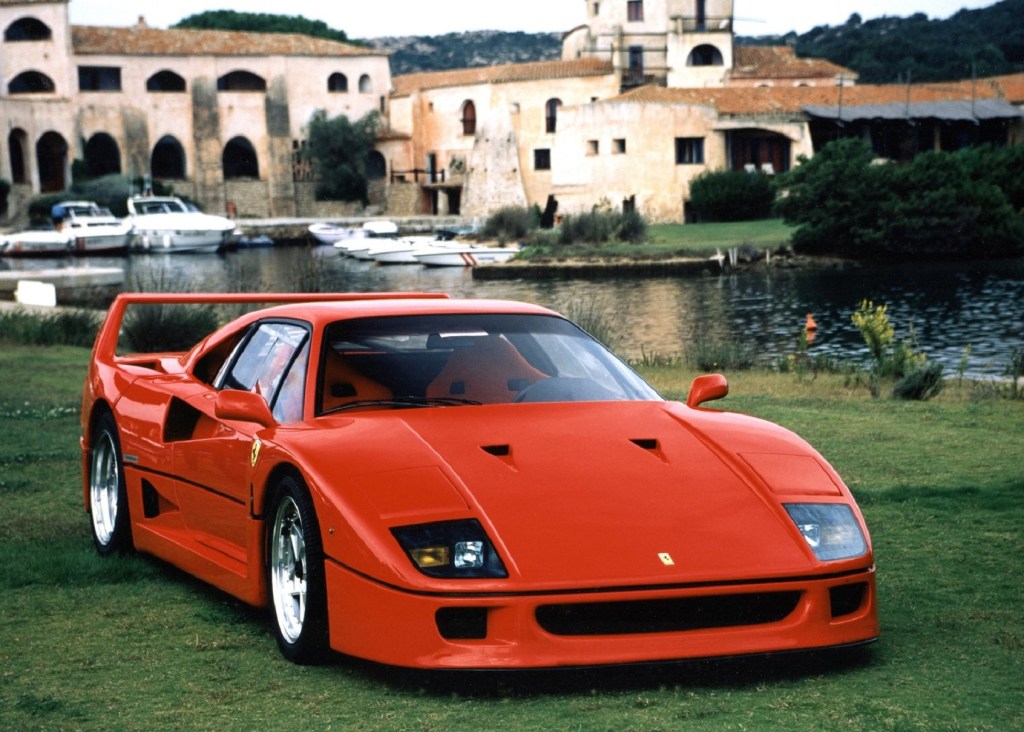 A red 1987 Ferrari F40 on the lawn of a European castle