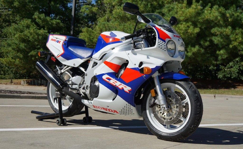 A white-red-and-blue 1993 Honda CBR900RR Fireblade on a rear-wheel stand