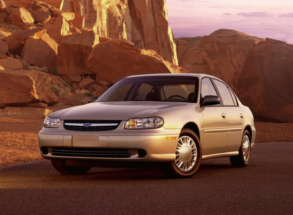 A tan 2002 Chevrolet Malibu amongst desert rocks