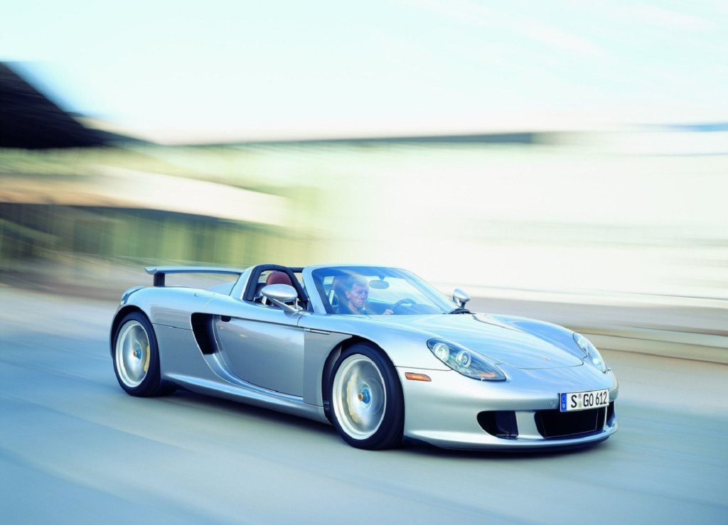 A silver 2004 Porsche Carrera GT being driven at speed