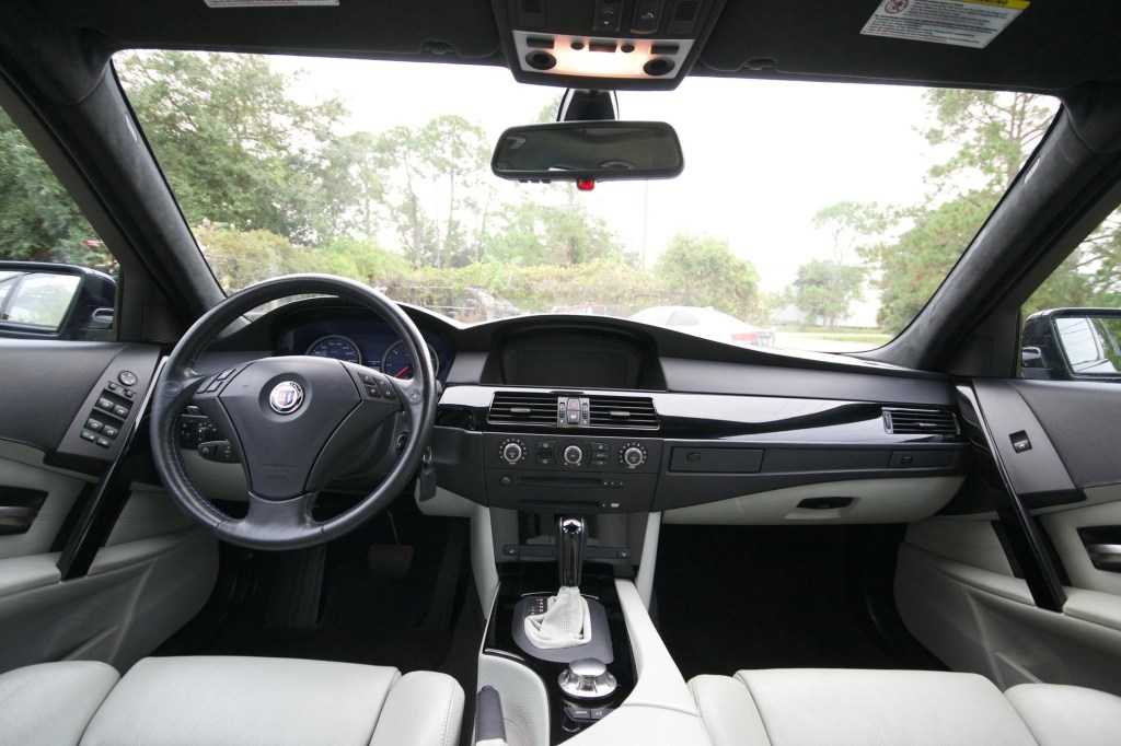 The white-leather front seats and black dashboard of a 2005 BMW Alpina B5