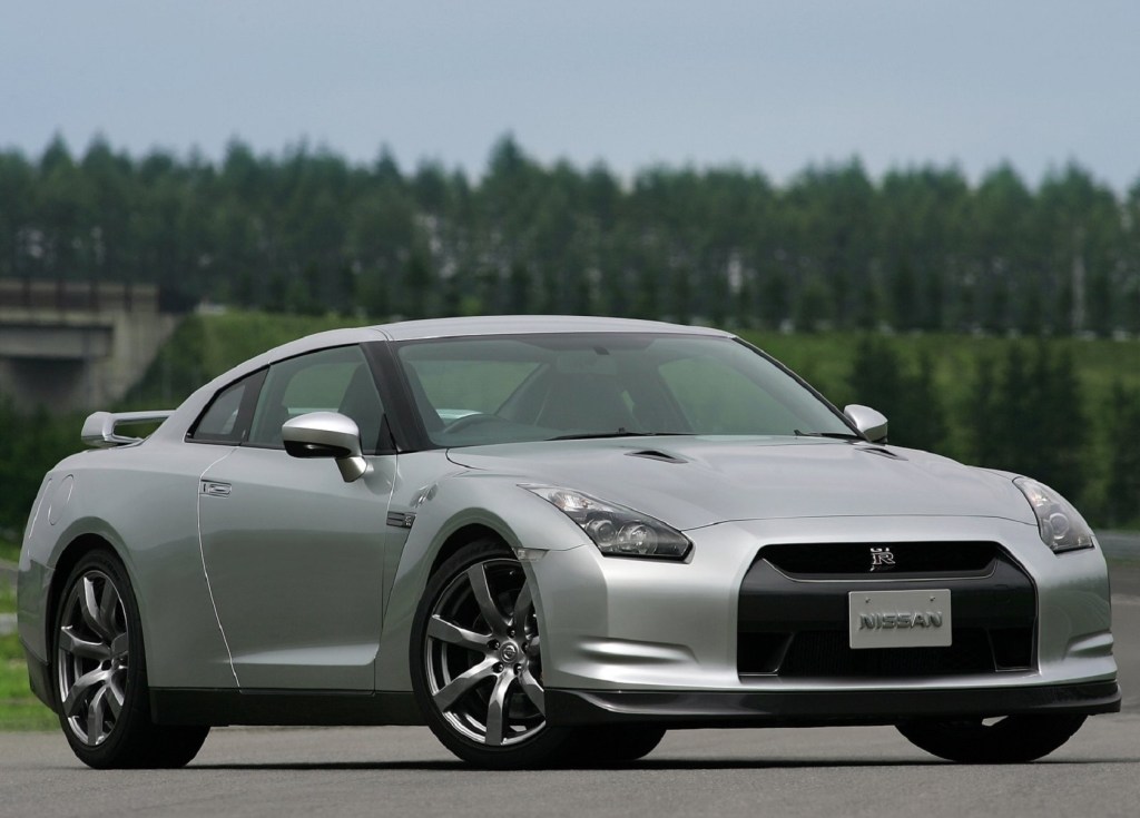 A silver 2009 Nissan GT-R on a track next to a forest