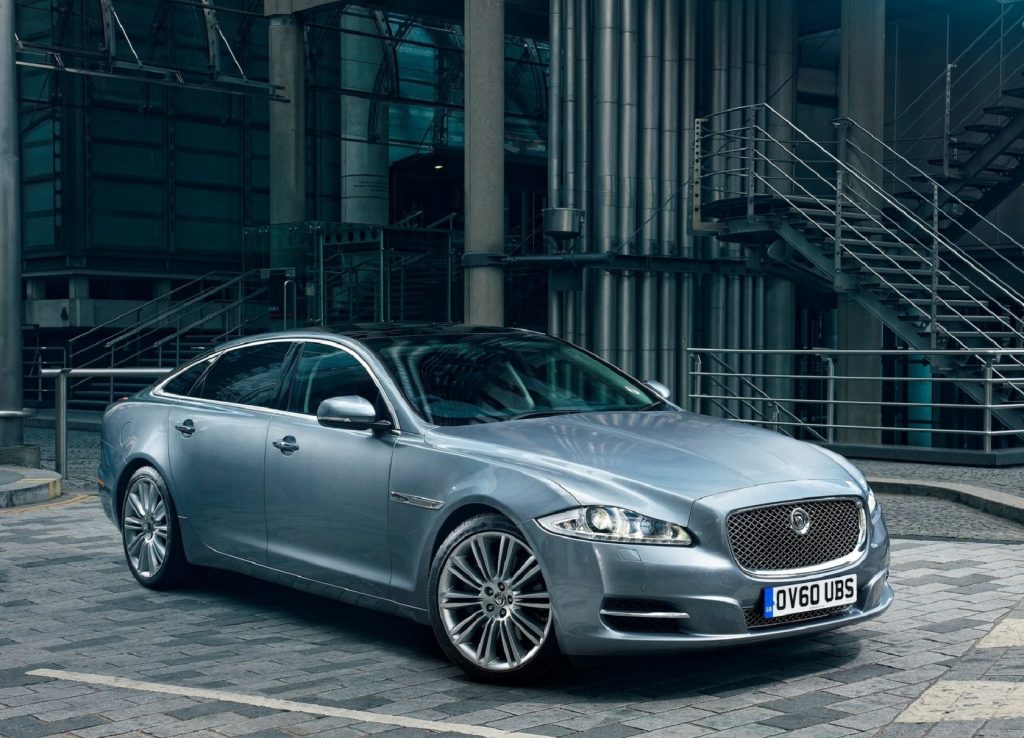A silver 2012 Jaguar XJ parked by a factory