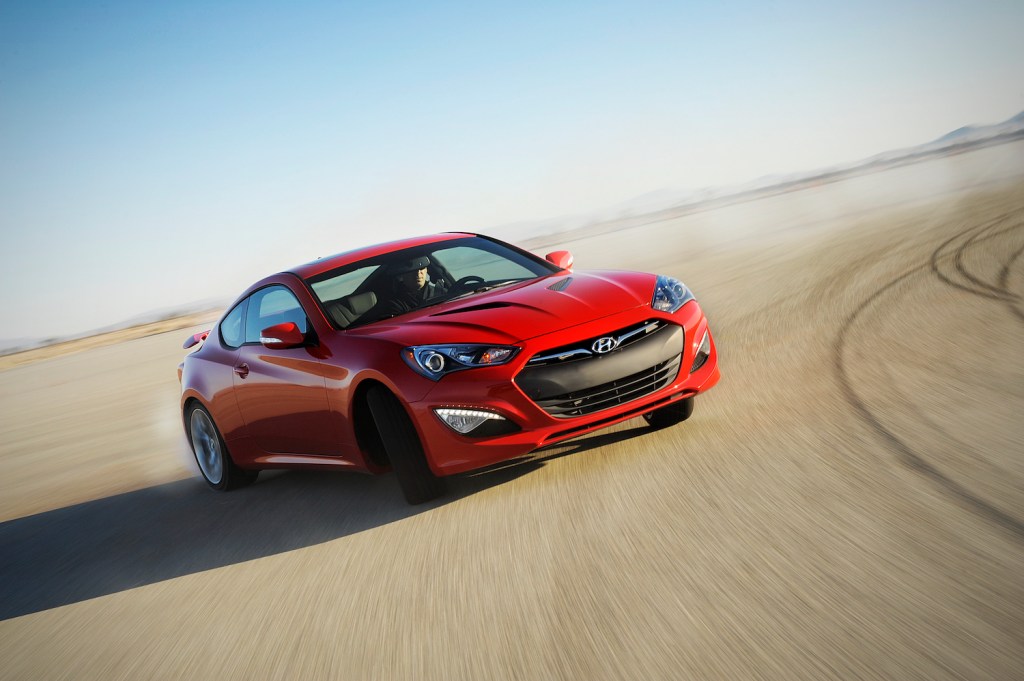 A red 2014 Hyundai Genesis Coupe driving, the 2014 Hyundai Genesis Coupe is one of the fastest used cars under $15,000