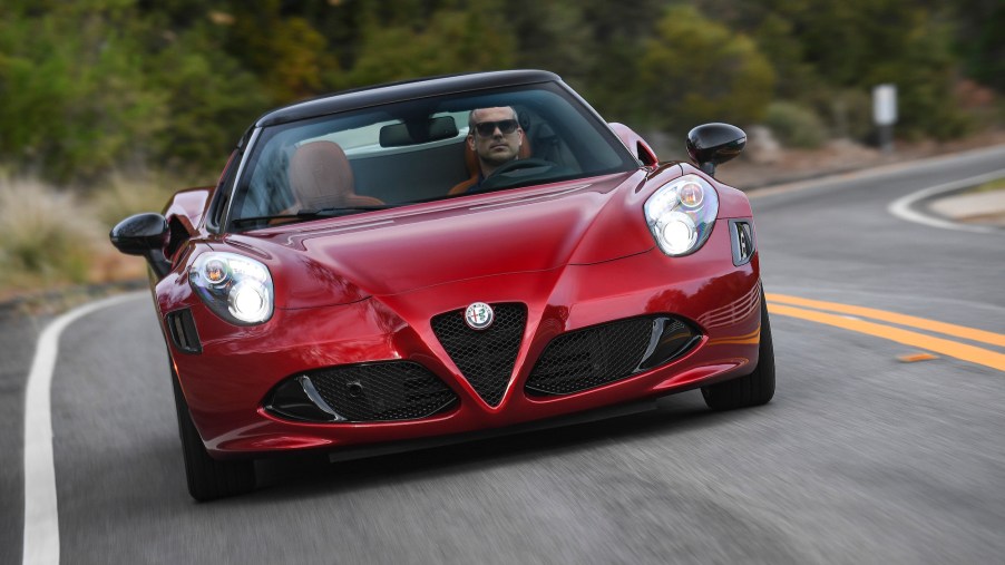 A dark-red 2020 Alfa Romeo 4C Spider 33 Stradale Tributo sports car travels on a winding highway