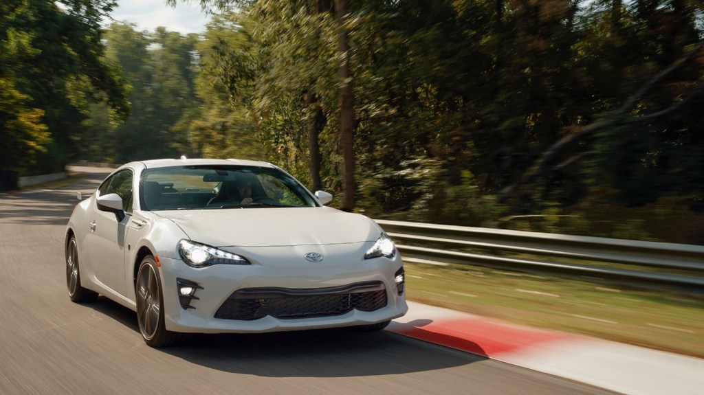 A white 2020 Toyota 86 GT with TRD Handling Package goes around a forested racetrack