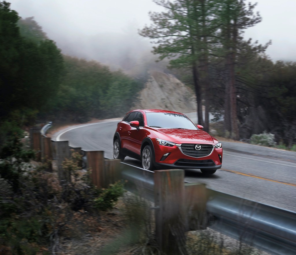 A red 2021 Mazda CX-3 driving, one of the most reliable new cars under $30,000