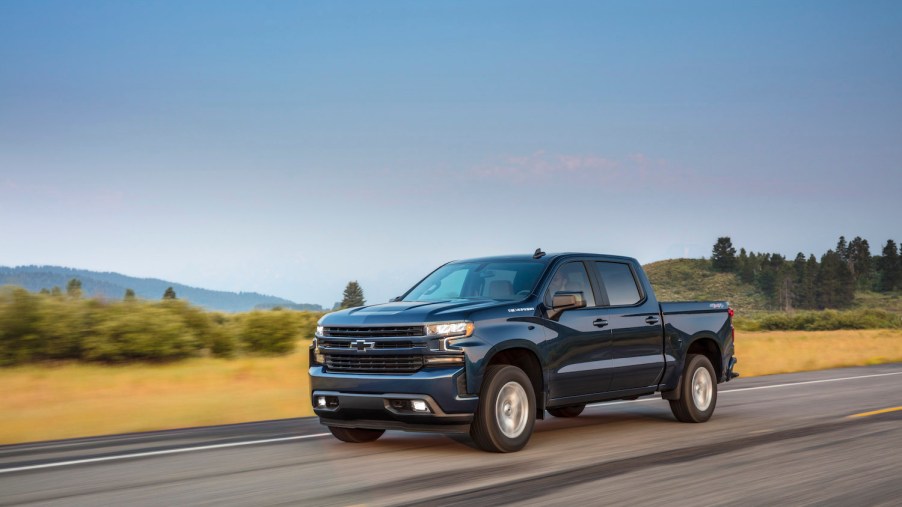 A blue 2021 Chevrolet Silverado driving on the road