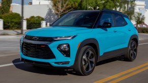 A bright-blue 2021 Chevrolet Trailblazer RS compact SUV traveling on a city road on a sunny day
