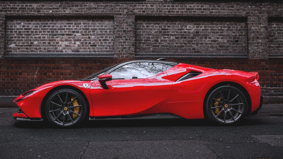A red Ferrari SF90 Stradale hypercar parked in front of a red-brick wall in Mayfair, London, in April 2021