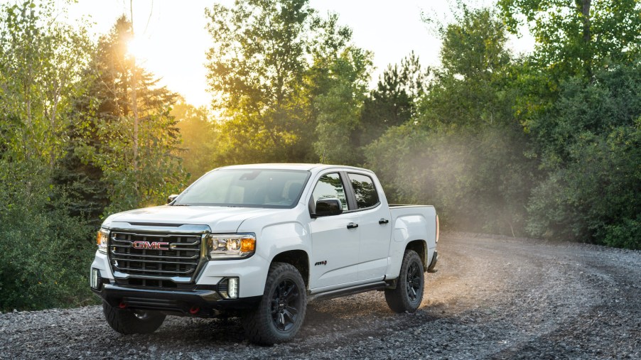 A white 2021 GMC Canyon driving, one of the best trucks for the value according to TrueCar