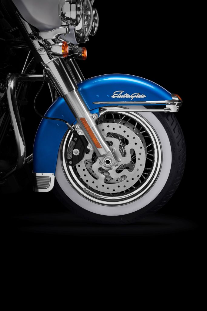 A close-up of a 2021 Harley-Davidson Electra Glide Revival's blue front fender and chrome-spoked wheel with whitewall tire