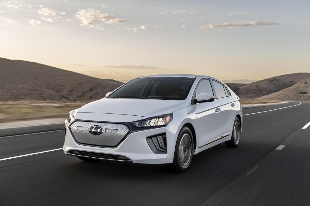 A white 2021 Hyundai Ioniq EV driving at sunset