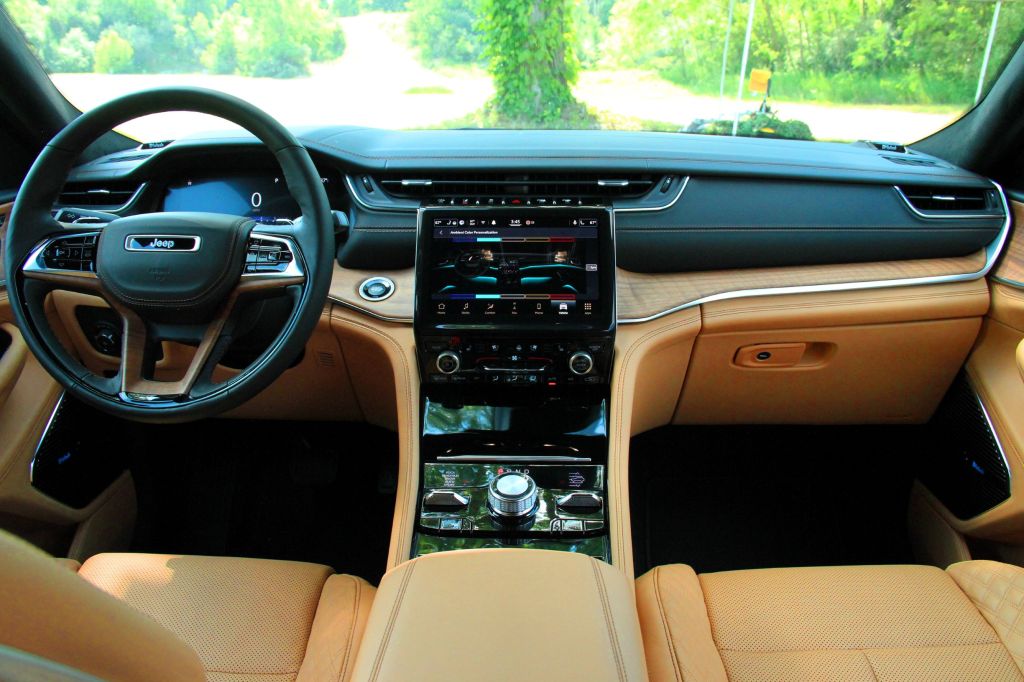 The tan-leather and wood-trimmed front interior of the 2021 Jeep Grand Cherokee L Summit Reserve