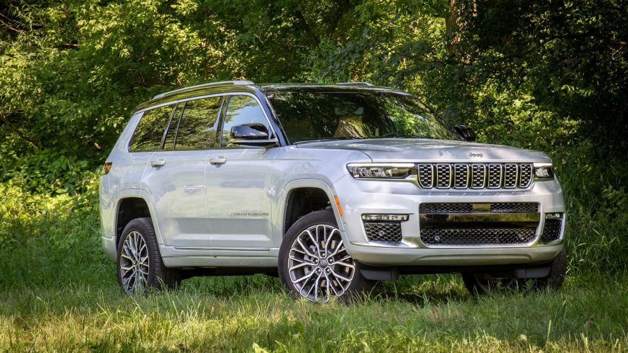 A white 2021 Jeep Grand Cherokee L Summit Reserve parked in the forest shade