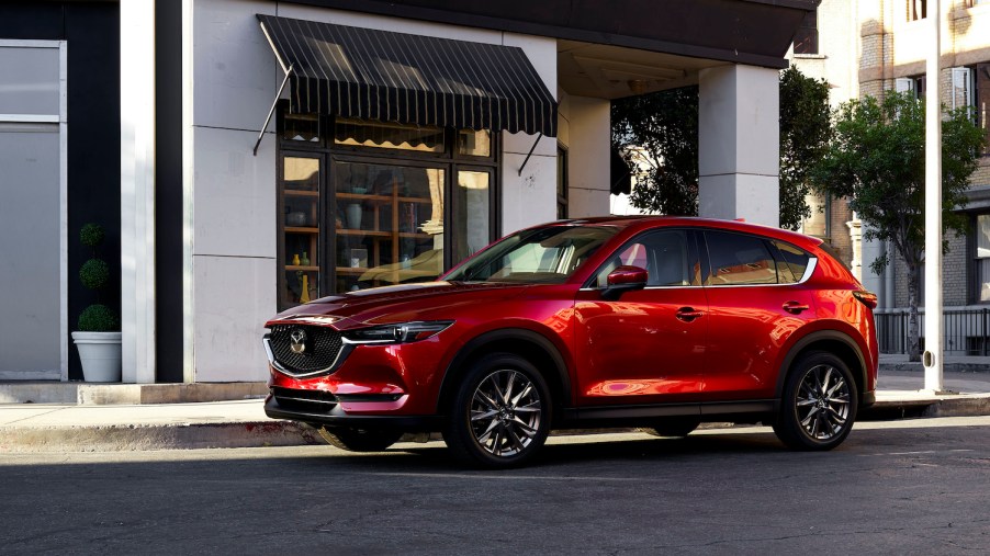 A red 2021 Mazda CX-5 parked in the city, the 2021 Mazda CX-5 is one of the best new SUVs under $30,000