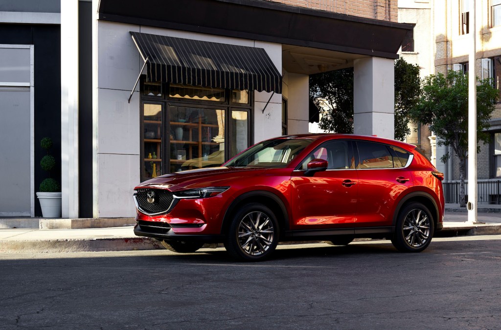 A red 2021 Mazda CX-5 parked, the 2021 Mazda CX-5 is one of the most reliable new SUVs under $30,000