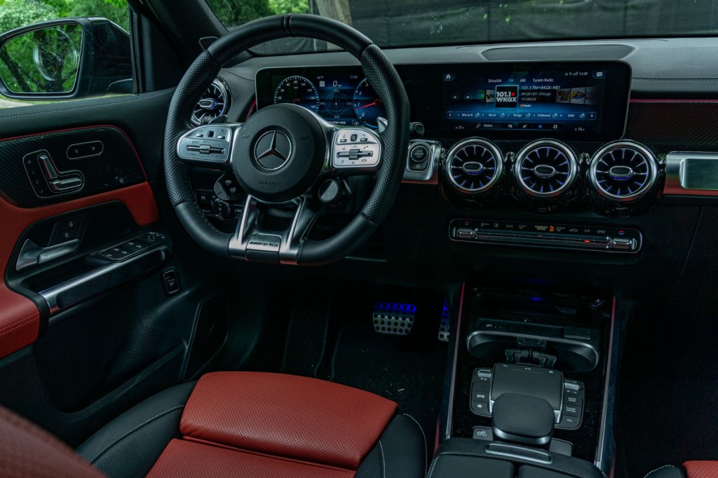 The red-and-black-leather interior of a 2021 Mercedes-AMG GLB 35 with its MBUX infotainment system active