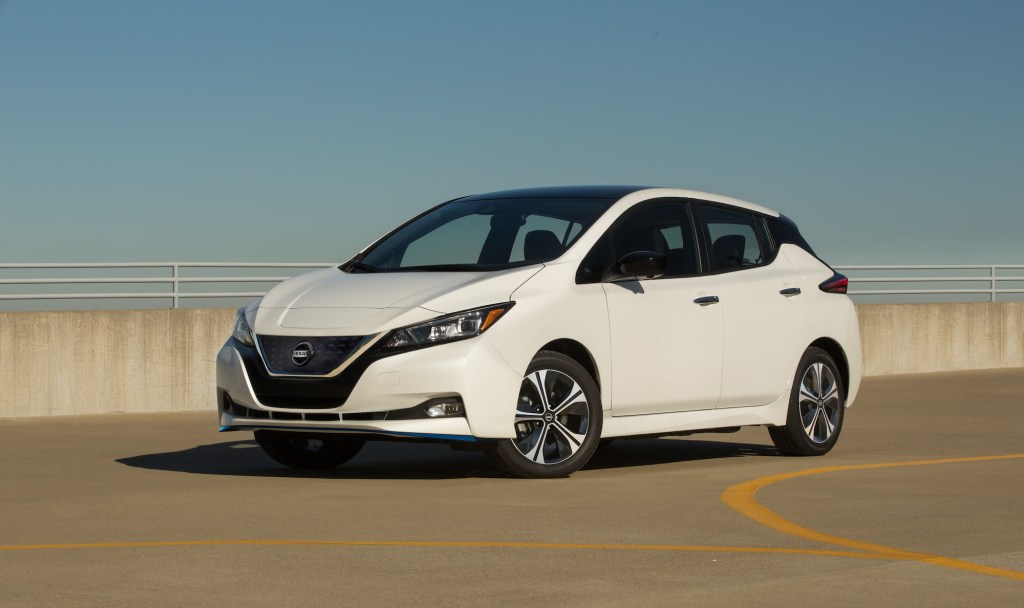 A white 2021 Nissan LEAF SV Plus electric car parked in a lot under a clear blue sky comes with a big discount for the 4th of july weekend