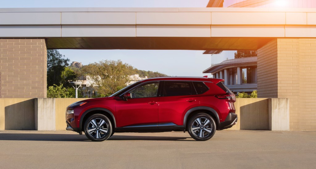 A red 2021 Nissan Rogue parked with the sun shining on it