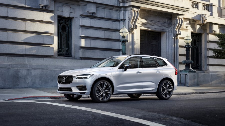 A 2021 Volvo XC60 Recharge Plug-In Hybrid R-Design in Crystal White Pearl stopped on a city street