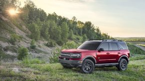 A red 2021 Ford Bronco Sport SUV parked outdoors in a wooded area